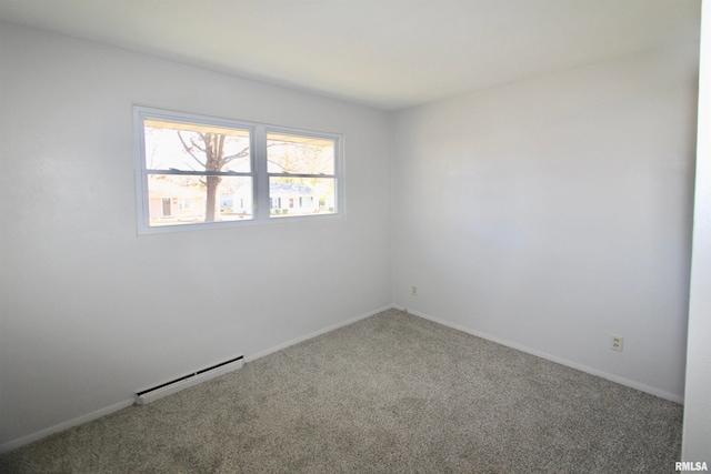 carpeted spare room with a baseboard heating unit