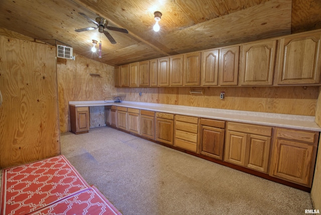 kitchen featuring lofted ceiling, wooden walls, built in desk, wooden ceiling, and light colored carpet