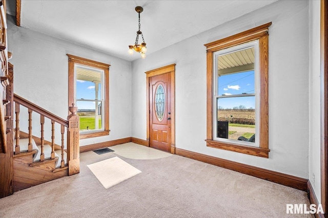 carpeted entryway with an inviting chandelier