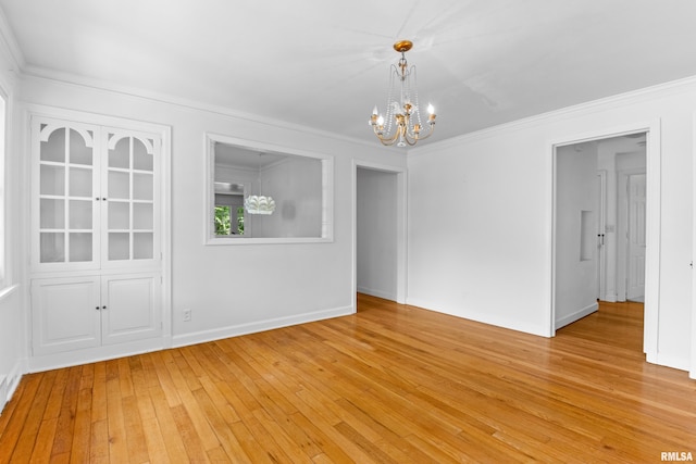 unfurnished dining area with a chandelier, light hardwood / wood-style flooring, and crown molding