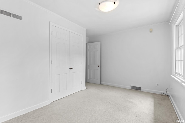 spare room featuring light colored carpet and ornamental molding