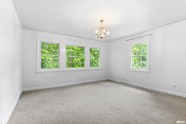 spare room with light carpet and an inviting chandelier