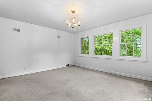 unfurnished room featuring carpet, a healthy amount of sunlight, and a notable chandelier