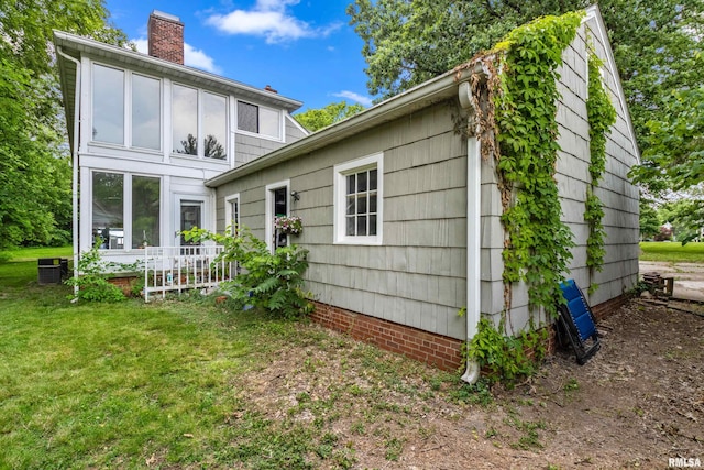 rear view of property featuring a yard and cooling unit