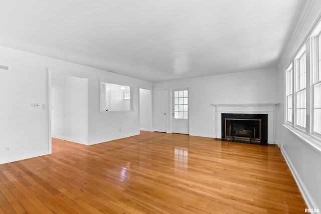 unfurnished living room with crown molding and light hardwood / wood-style floors