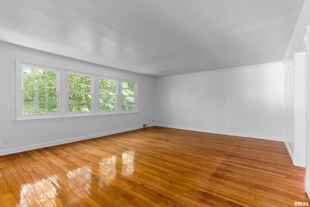 spare room with crown molding and light wood-type flooring