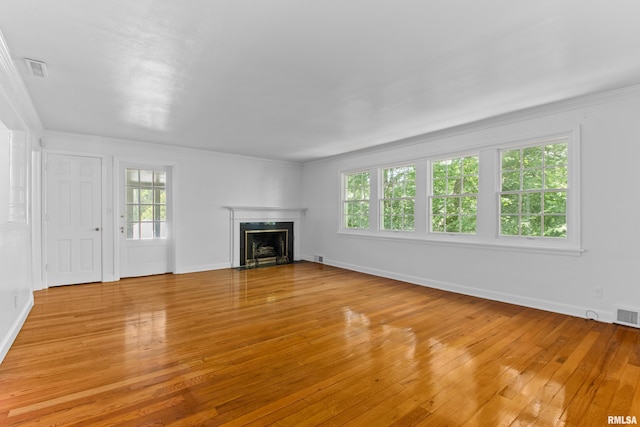 unfurnished living room with light hardwood / wood-style flooring and ornamental molding