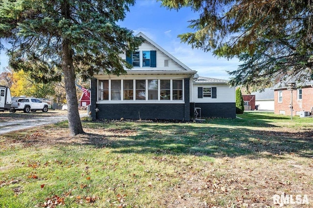 view of front of house featuring a sunroom and a front lawn