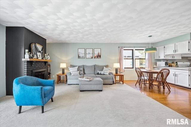 living room with a fireplace and light wood-type flooring