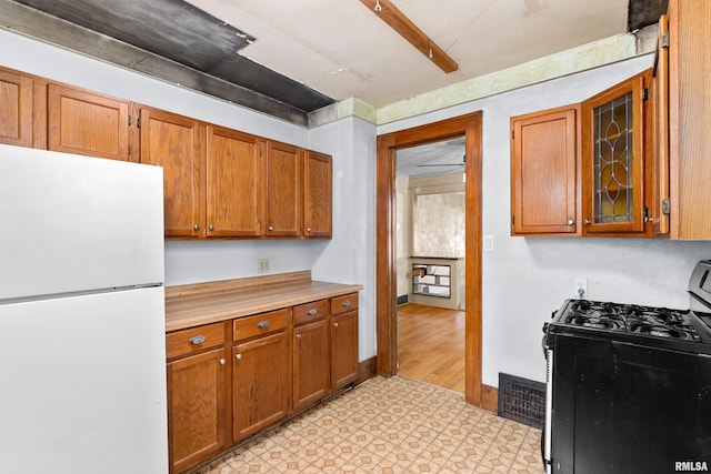 kitchen featuring stainless steel gas range and white fridge