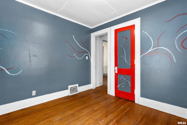 spare room featuring hardwood / wood-style flooring and crown molding