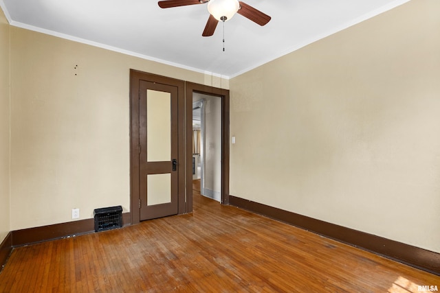 empty room with ceiling fan, wood-type flooring, and ornamental molding