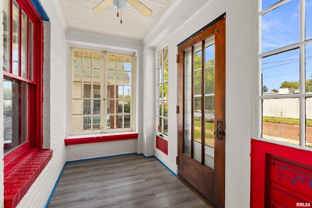 unfurnished sunroom with ceiling fan