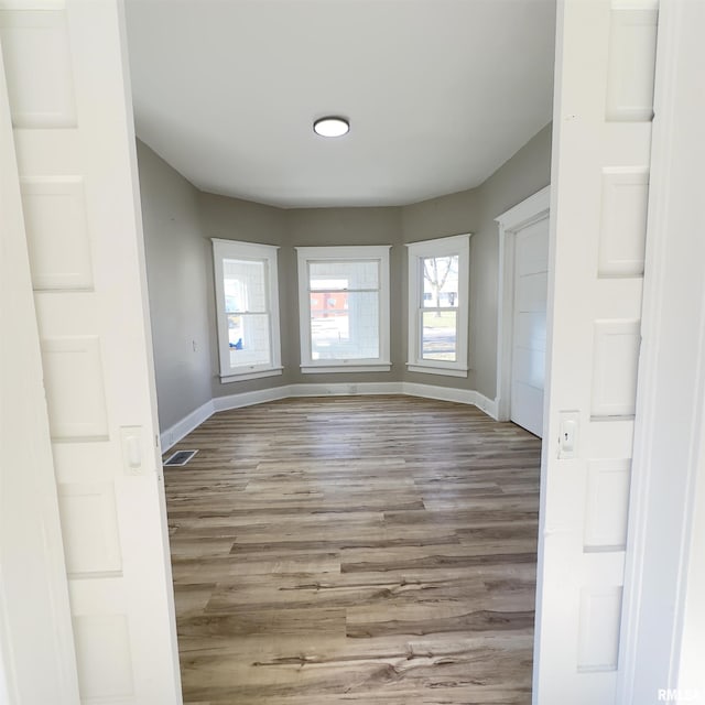 kitchen with white cabinetry, stainless steel gas stove, and light hardwood / wood-style flooring