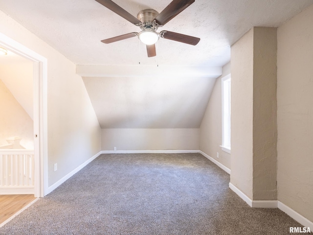 additional living space featuring a textured ceiling, ceiling fan, carpet, and vaulted ceiling