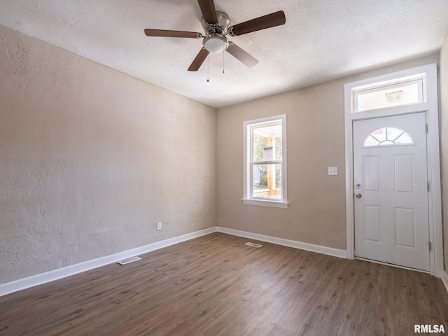 entryway featuring a textured ceiling, ceiling fan, and dark wood-type flooring