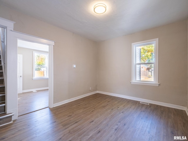 spare room with hardwood / wood-style floors and plenty of natural light