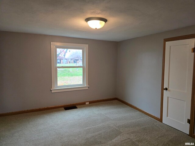 empty room with a textured ceiling and carpet floors