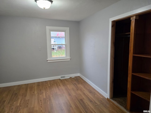 unfurnished bedroom with wood-type flooring and a closet