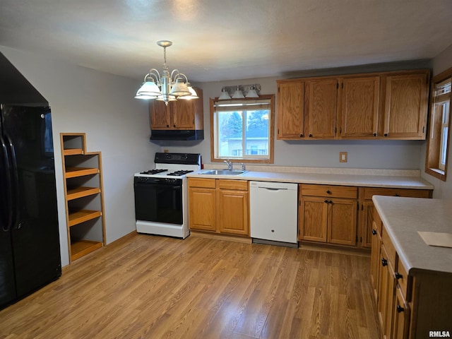 kitchen with white appliances, sink, decorative light fixtures, light hardwood / wood-style flooring, and a notable chandelier