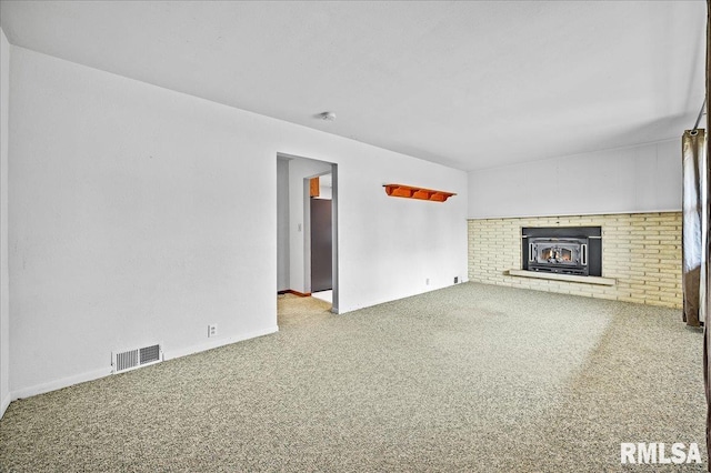 unfurnished living room with carpet flooring and a wood stove