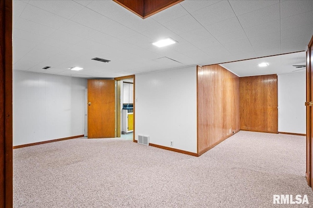 basement with wooden walls and light colored carpet