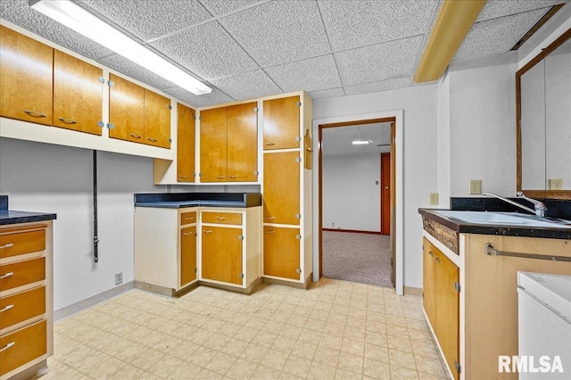 kitchen with a paneled ceiling and sink