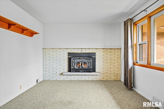 unfurnished living room featuring carpet and a wood stove