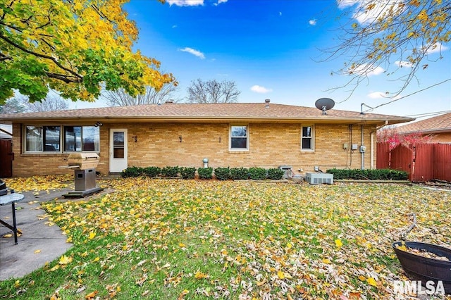 back of property with a lawn and cooling unit