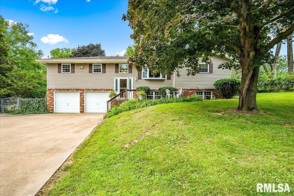 raised ranch with a garage and a front yard