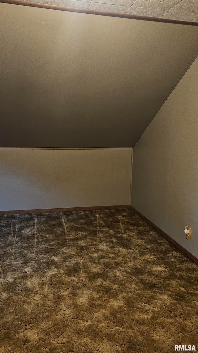 bonus room featuring lofted ceiling and dark colored carpet