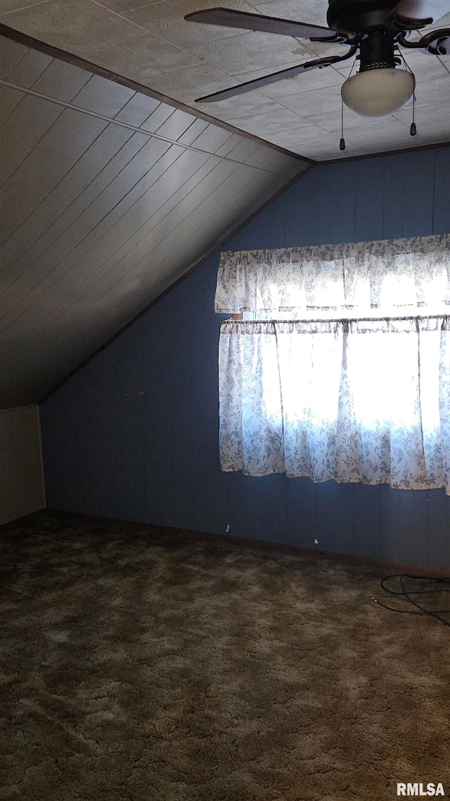 bonus room featuring ceiling fan, dark carpet, and lofted ceiling