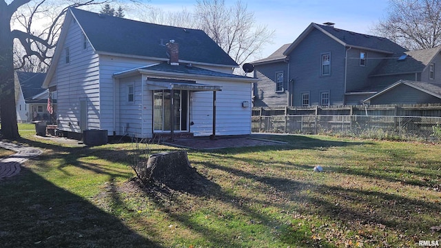 back of property featuring a lawn