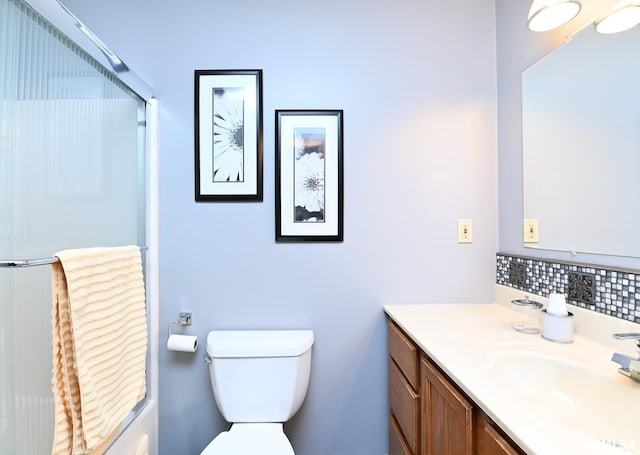 bathroom featuring vanity, tasteful backsplash, toilet, and walk in shower