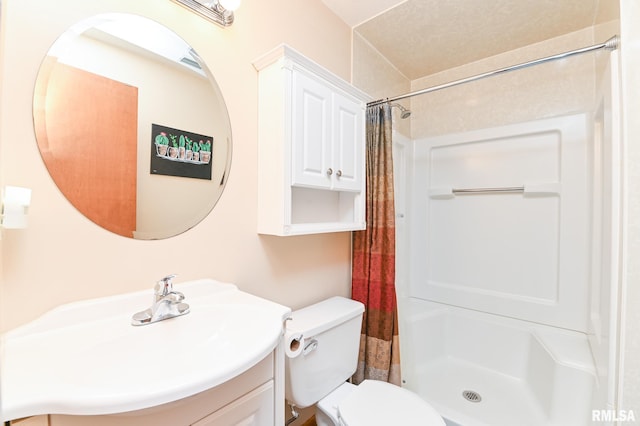 bathroom with walk in shower, vanity, and toilet