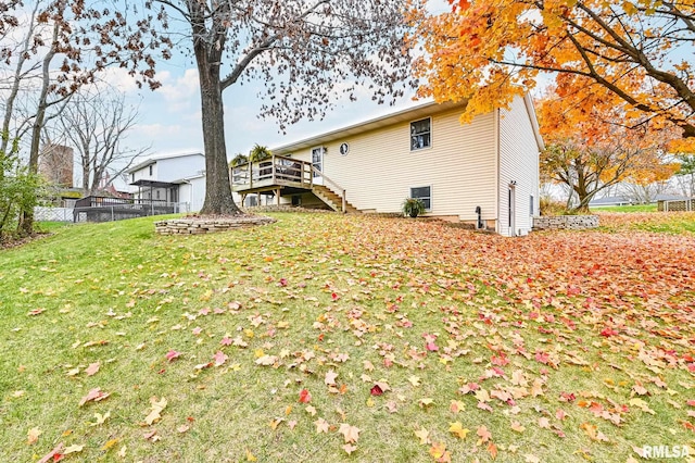 back of property featuring a lawn and a wooden deck