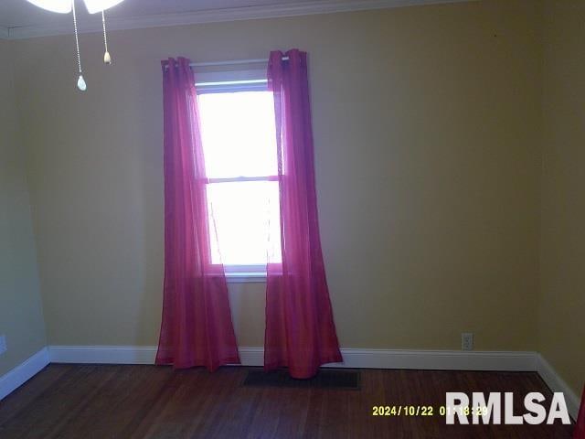 unfurnished room with crown molding and dark wood-type flooring