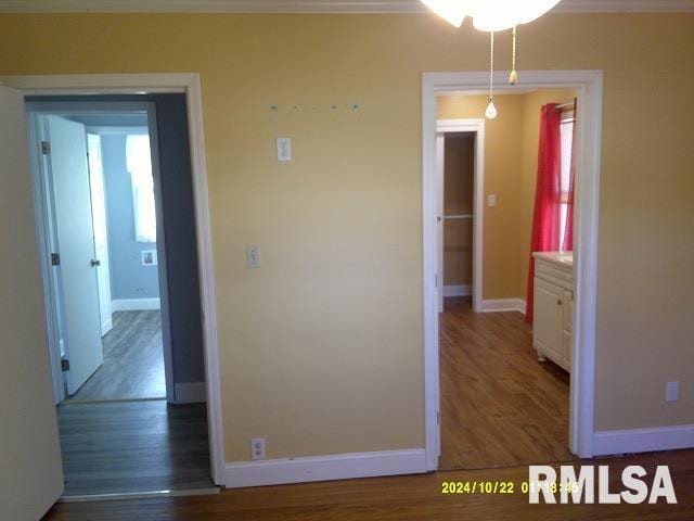 hallway with crown molding and dark wood-type flooring