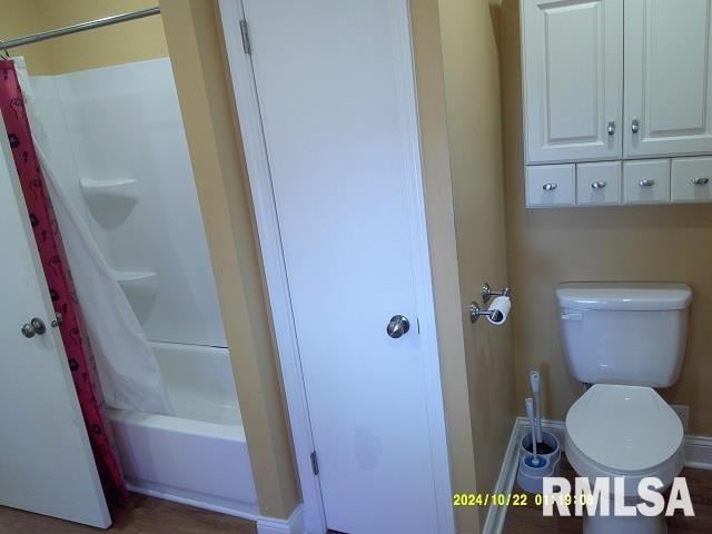 bathroom with shower / tub combo and toilet