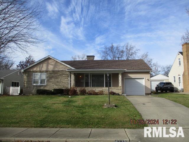 view of front of property with a garage and a front lawn