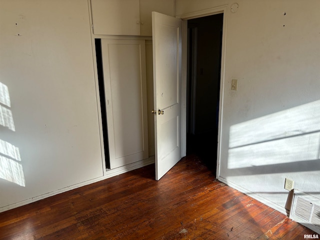 unfurnished bedroom with dark wood-type flooring