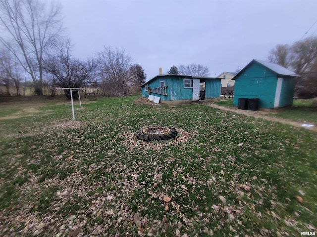 view of yard with a fire pit and an outdoor structure