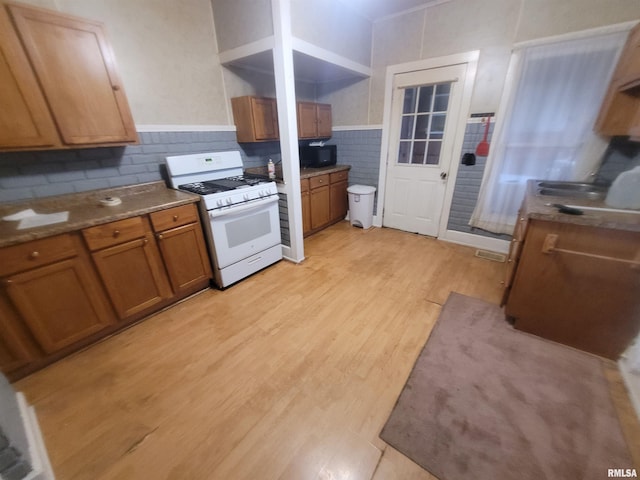 kitchen with white gas range oven and light hardwood / wood-style flooring