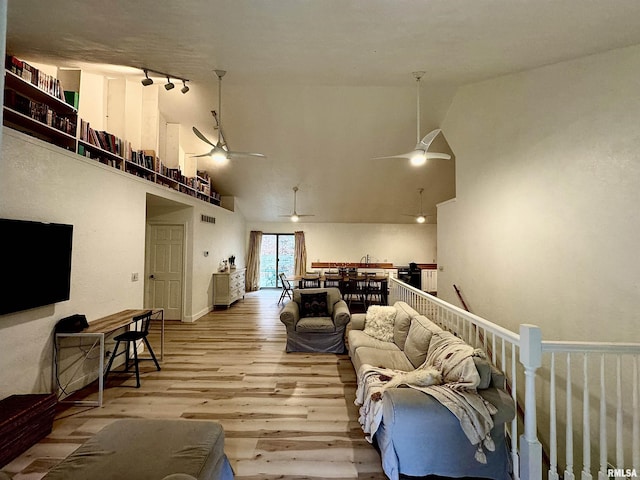 living room featuring light hardwood / wood-style flooring, high vaulted ceiling, ceiling fan, and track lighting