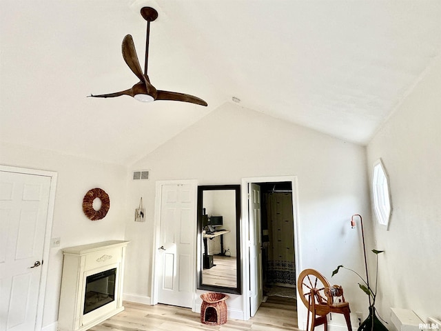 interior space with lofted ceiling, ceiling fan, and light wood-type flooring