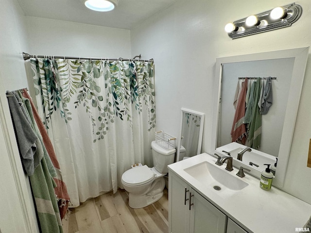 bathroom featuring hardwood / wood-style flooring, vanity, toilet, and walk in shower