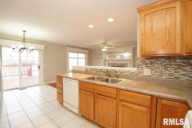 kitchen with tasteful backsplash, ceiling fan with notable chandelier, sink, pendant lighting, and dishwasher