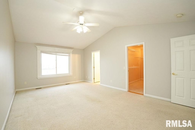 carpeted spare room with ceiling fan and vaulted ceiling