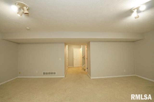 basement with a textured ceiling and light carpet