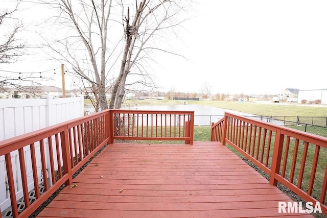 wooden deck featuring a lawn and a water view